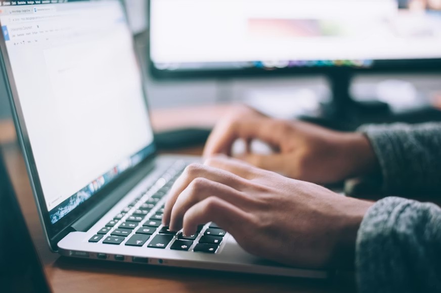 Profissional de TI trabalhando em notebook prestando suporte HelpDesk